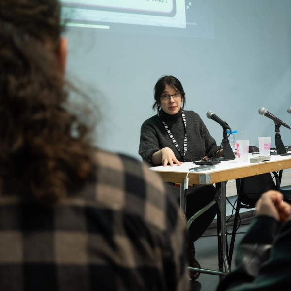 HappyPathLAB speaker answering questions from a panel table at a game industry event