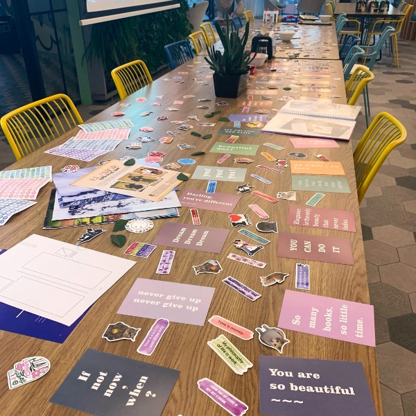 Vision board workshop materials: cards, stickers and magazines spread across a table